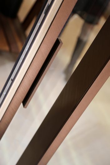 Detail of the handle of a lift covered in brushed bronze aluminum