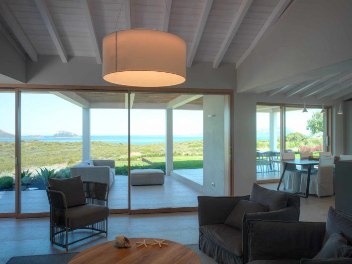 View of the living room of Villa Costa Smeralda with two sliding windows on the back wall