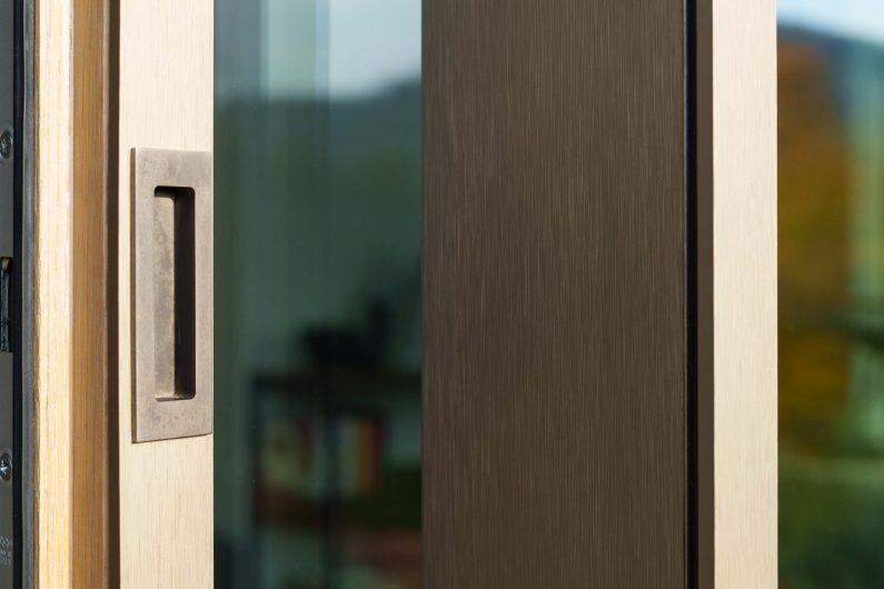 Detail of the external handle of the lift and slide Skyline with bronze aluminium cladding